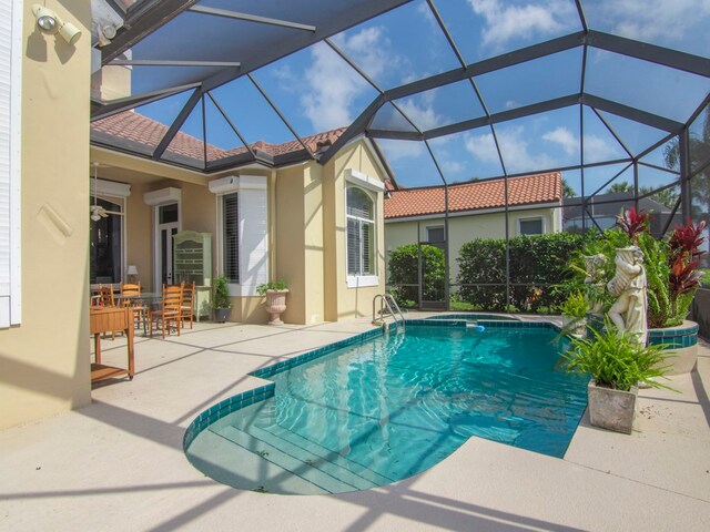 view of swimming pool with a lanai, ceiling fan, and a patio