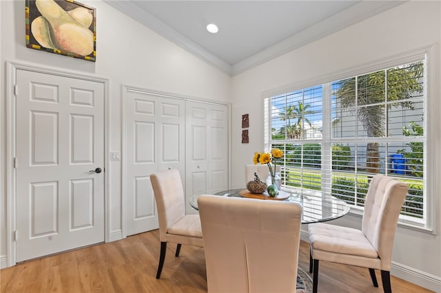 dining space with vaulted ceiling, wood-type flooring, and ornamental molding