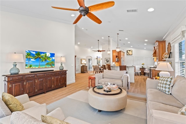 living room featuring crown molding, ceiling fan, vaulted ceiling, and light wood-type flooring