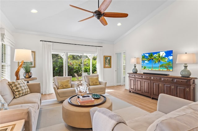 living room with vaulted ceiling, plenty of natural light, crown molding, and light hardwood / wood-style flooring