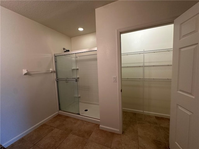 full bathroom featuring baseboards, a shower stall, recessed lighting, and a spacious closet