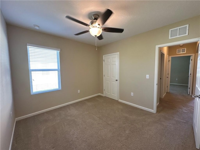 unfurnished bedroom with visible vents, carpet flooring, and baseboards
