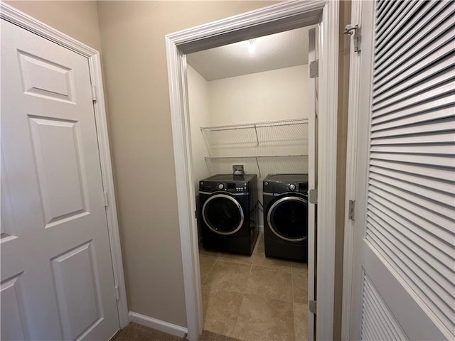 laundry area with baseboards, tile patterned flooring, laundry area, and washer and clothes dryer