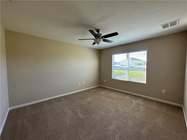 unfurnished room with visible vents, carpet, baseboards, and ceiling fan