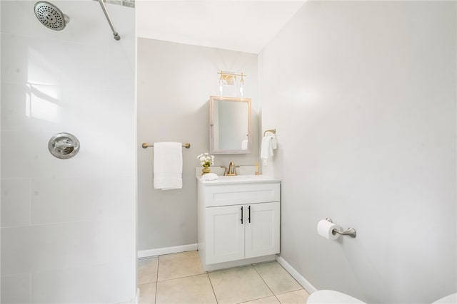 bathroom with tile patterned flooring, vanity, and a tile shower