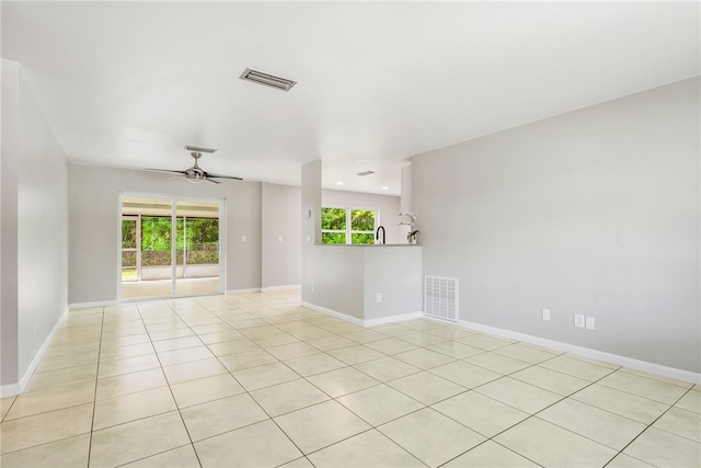 tiled empty room featuring a wealth of natural light and ceiling fan