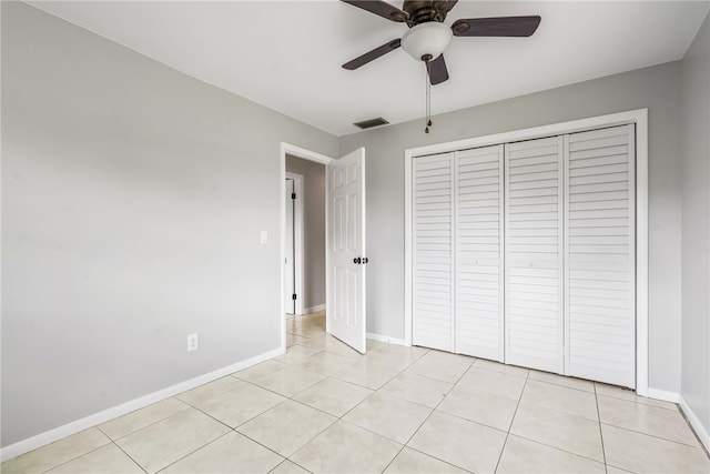 unfurnished bedroom featuring a closet, light tile patterned floors, and ceiling fan