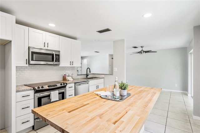 kitchen with white cabinetry, stainless steel appliances, sink, and ceiling fan