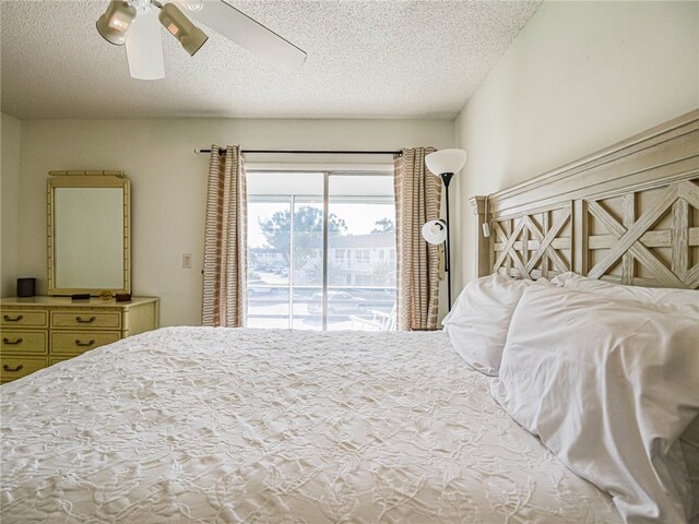 bedroom with access to outside, a textured ceiling, and ceiling fan