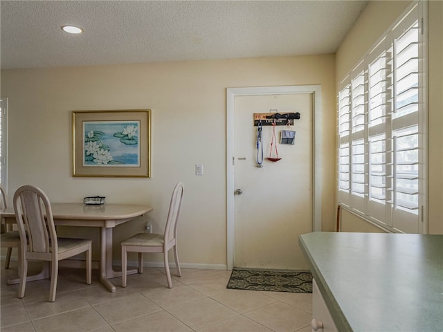 dining room featuring a textured ceiling and light tile patterned floors