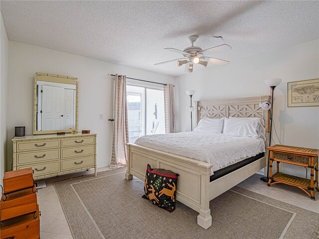 bedroom with a textured ceiling, tile patterned flooring, and ceiling fan