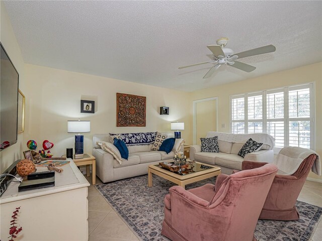 living room with a textured ceiling, light tile patterned floors, and ceiling fan