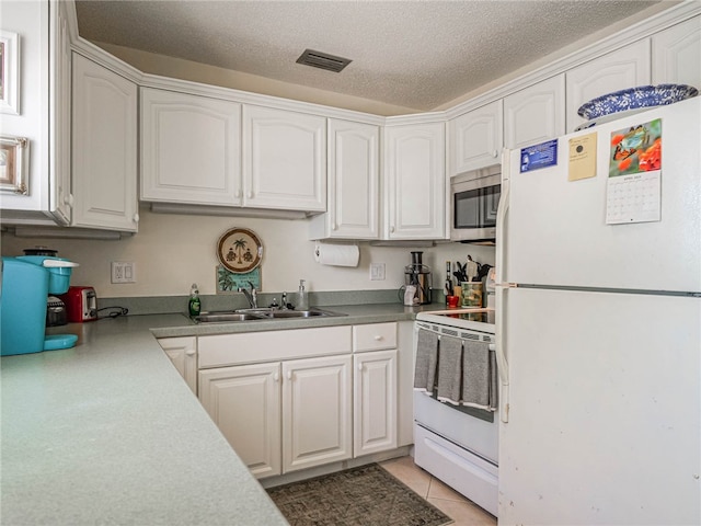 kitchen featuring white cabinetry, a textured ceiling, light tile patterned floors, sink, and white appliances