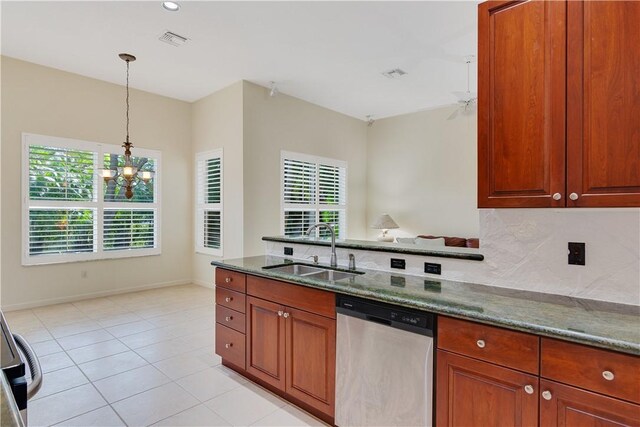 9520 E Maiden Ct, Vero Beach, FL 32963 - kitchen with stainless steel dishwasher, a sink, dark stone countertops, decorative light fixtures, and a chandelier
