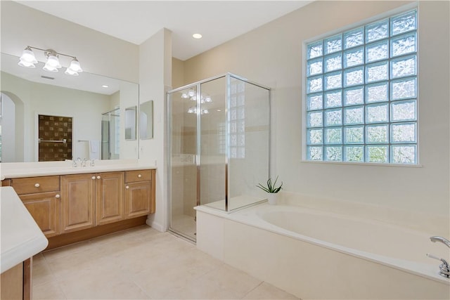 9520 E Maiden Ct, Vero Beach, FL 32963 - bathroom with vanity, a garden tub, a stall shower, and tile patterned flooring