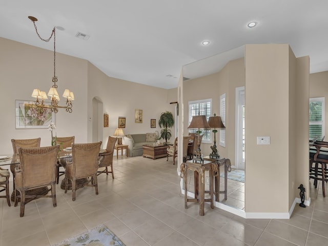 tiled dining room featuring a chandelier