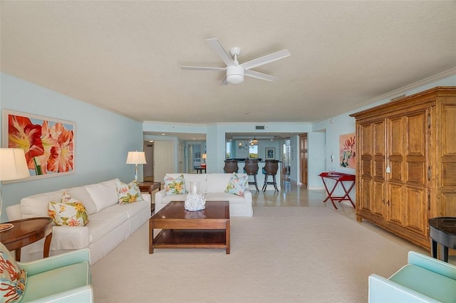 carpeted living room featuring crown molding, a textured ceiling, and ceiling fan