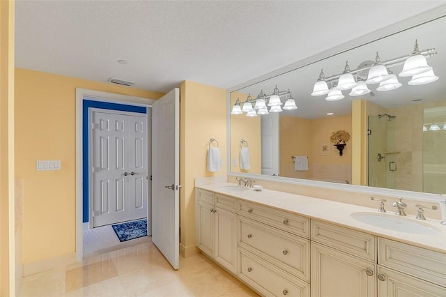 bathroom with vanity, a shower with door, and a textured ceiling