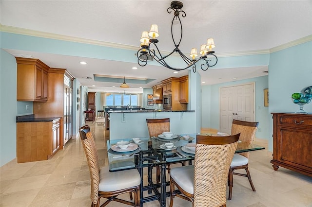 dining room with ornamental molding, a chandelier, and a tray ceiling