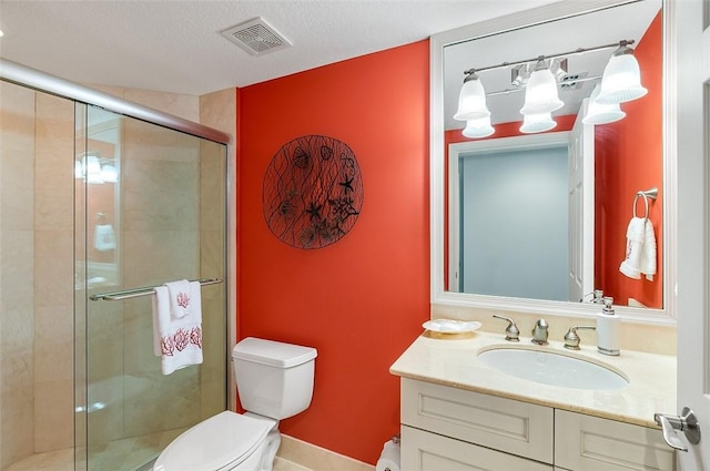 bathroom with vanity, a textured ceiling, a shower with door, and toilet