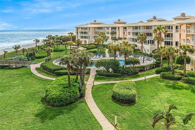 view of property's community featuring a lawn and a water view