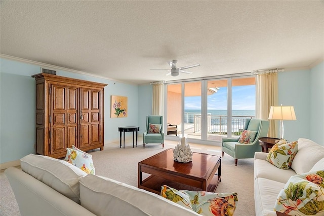 carpeted living room featuring a wall of windows, ornamental molding, ceiling fan, a water view, and a textured ceiling