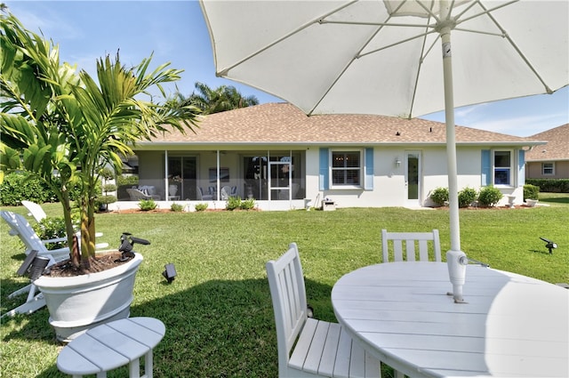 rear view of property with a sunroom and a yard