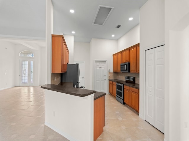 kitchen featuring kitchen peninsula, decorative backsplash, and appliances with stainless steel finishes