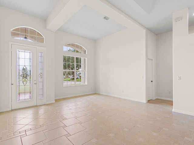 entryway featuring beam ceiling and light tile patterned floors