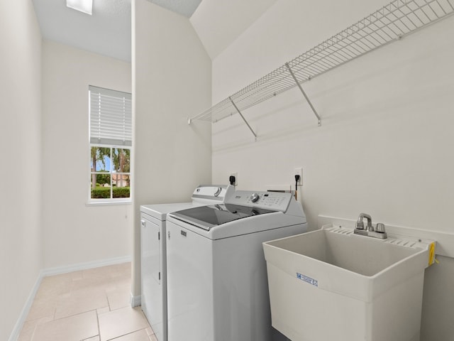 laundry room with washing machine and dryer, sink, and light tile patterned floors