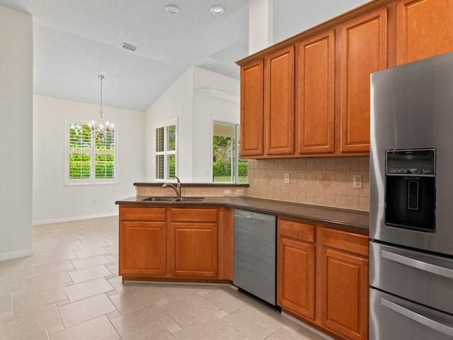 kitchen featuring stainless steel appliances, plenty of natural light, sink, and vaulted ceiling