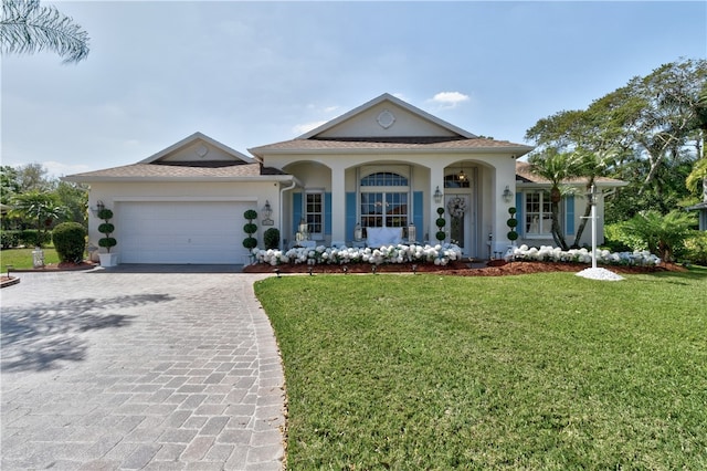 view of front of property featuring a garage, a front yard, and covered porch