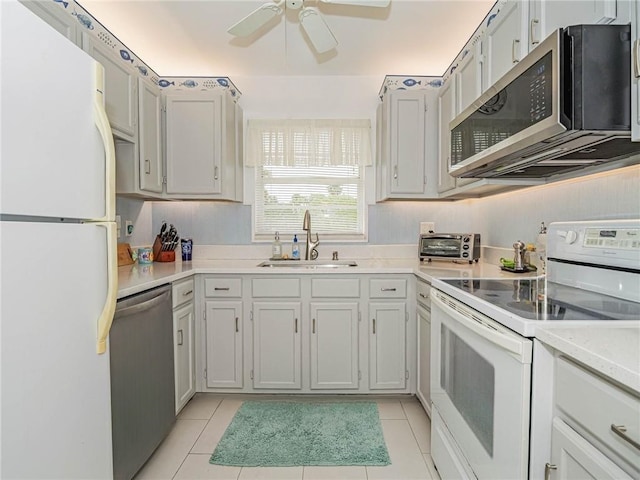 kitchen featuring light countertops, appliances with stainless steel finishes, a ceiling fan, light tile patterned flooring, and a sink