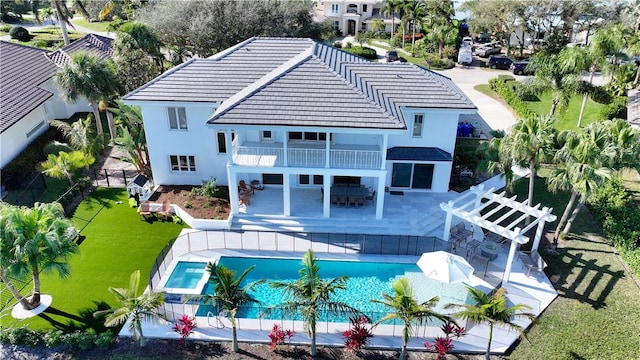 back of house with a patio area, a balcony, a yard, outdoor lounge area, and a pergola