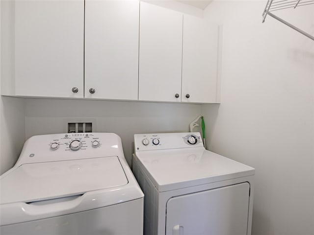 washroom featuring cabinets and independent washer and dryer