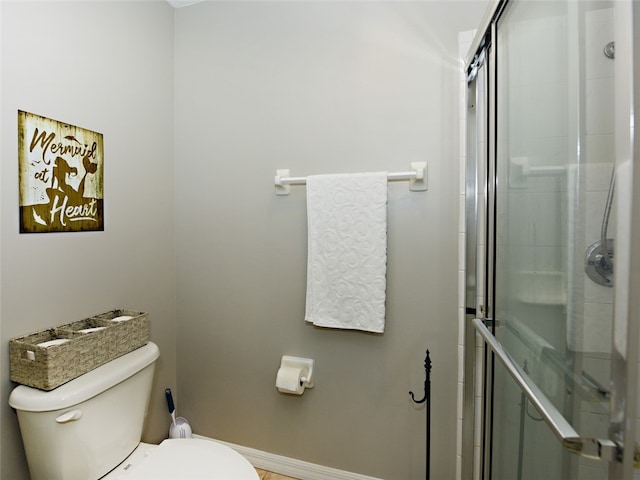 bathroom with an enclosed shower and toilet