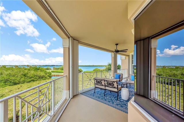 balcony featuring a water view and ceiling fan