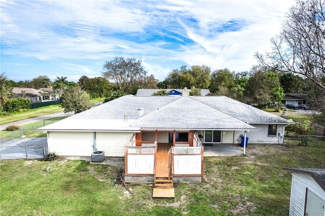 back of house with cooling unit, a lawn, and a wooden deck