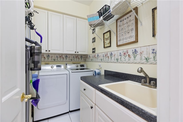 clothes washing area featuring light tile patterned flooring, cabinets, washer and clothes dryer, and sink