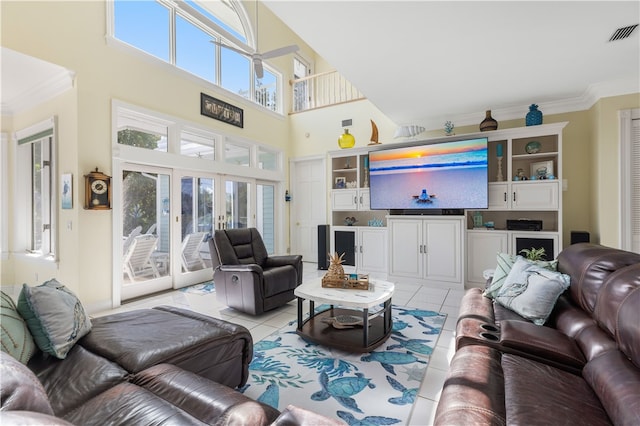 tiled living room featuring crown molding, a towering ceiling, and french doors