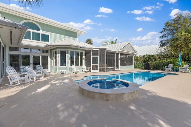 view of swimming pool featuring an in ground hot tub, a sunroom, and a patio area