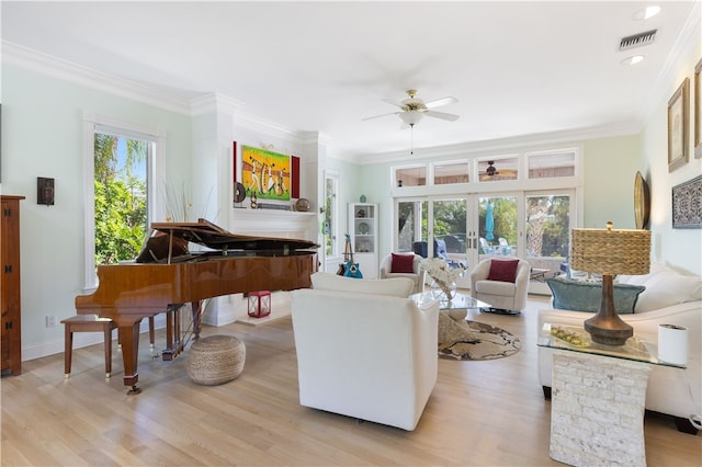 living room with ornamental molding, a wealth of natural light, ceiling fan, and light hardwood / wood-style floors