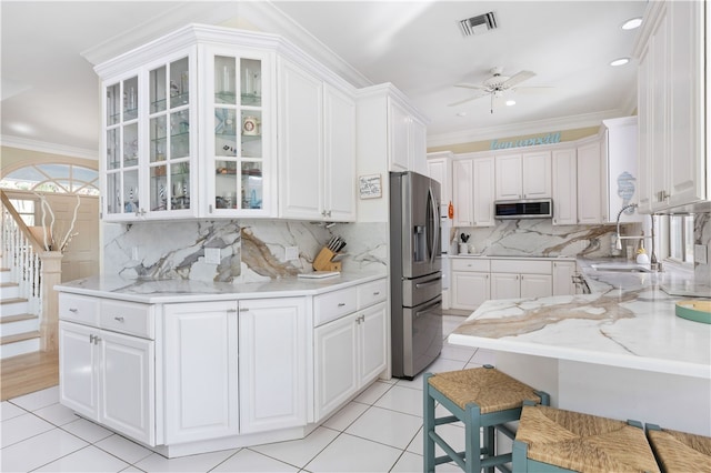 kitchen with crown molding, appliances with stainless steel finishes, and white cabinets