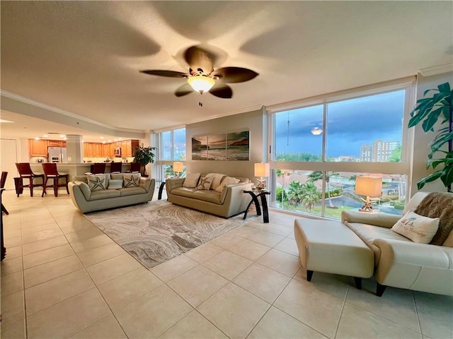 living room with ceiling fan, crown molding, and light tile patterned floors