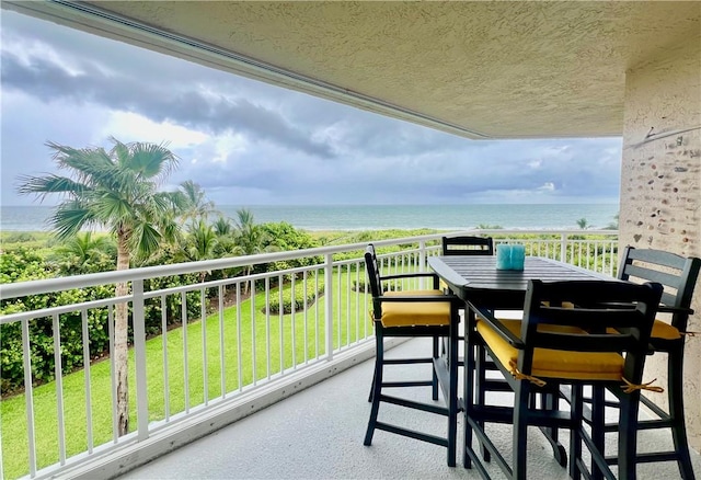 balcony featuring a water view and a beach view