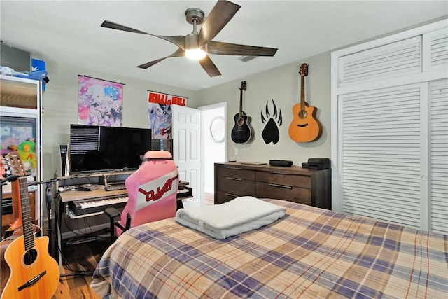 bedroom featuring hardwood / wood-style flooring, ceiling fan, and a closet