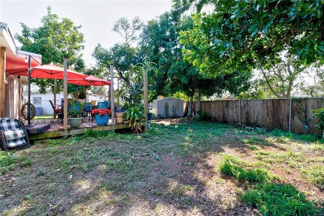 view of yard featuring a wooden deck and a shed