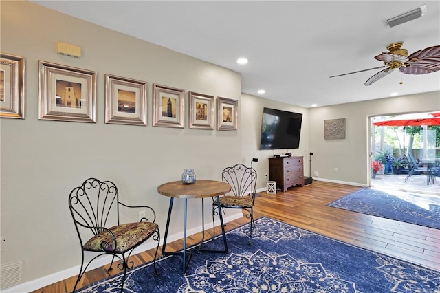 sitting room with wood-type flooring and ceiling fan
