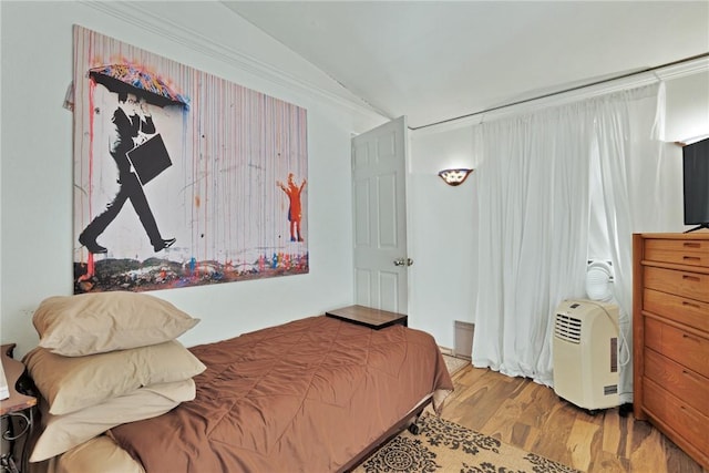 bedroom with vaulted ceiling and light hardwood / wood-style floors