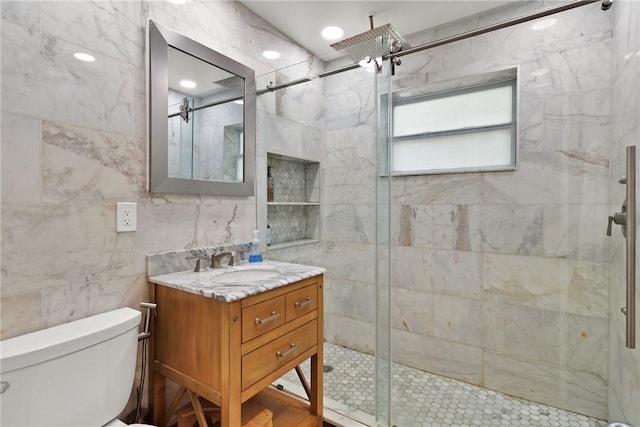bathroom featuring vanity, tile walls, toilet, and walk in shower